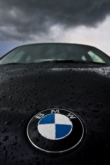 Photo of BMW emblem with dark skies over head.